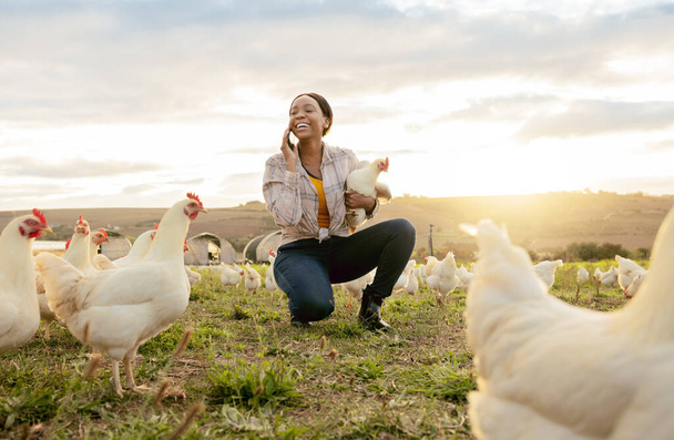 Black woman, phone call and countryside on chicken farm with smile for live stock in the outdoors. Happy African American female farmer smiling on phone for sustainability, agriculture and animals. - Fotó, kép