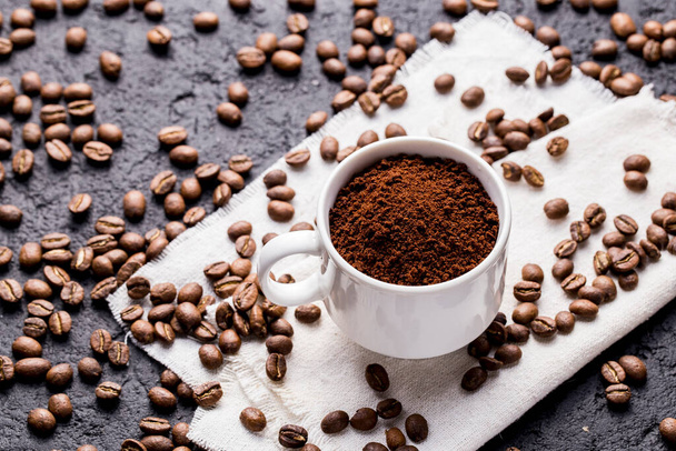 Roasted coffee beans and ground coffee, on dark background, closeup image, space for text - Φωτογραφία, εικόνα