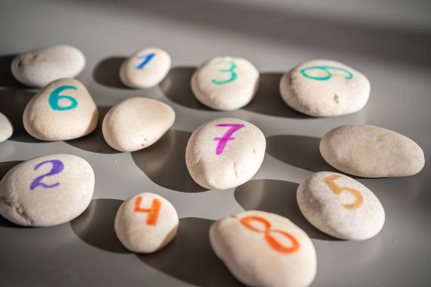 Pedras coloridas assinadas por números, um método alternativo de educação infantil. Número 7 no centro. Foto de alta qualidade - Foto, Imagem