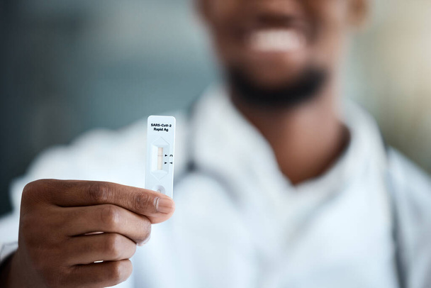 Covid, hand and antigen rapid test with a black man showing his negative result after a medical exam. Health, wellness and insurance with a male holding up a reading on a corona virus testing kit. - Valokuva, kuva