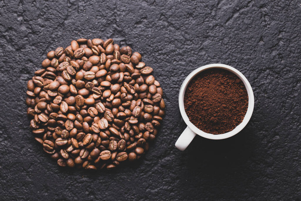 Ψητά φασόλια καφέ και αλεσμένο καφέ, σε σκούρο φόντο, εικόνα closeup, χώρος για κείμενο - Φωτογραφία, εικόνα