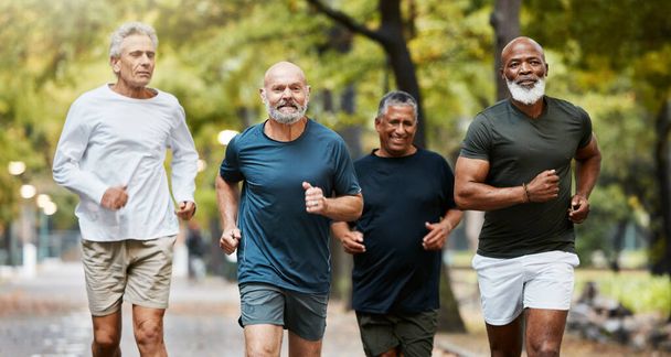 Мбаппе, бег и группа старших мужчин вместе занимаются физическими упражнениями, тренировками и тренировками в парке в выходные. Природа, дружба и старые парни, занимающиеся спортом на свежем воздухе для здоровья, благополучия и ухода за телом. - Фото, изображение