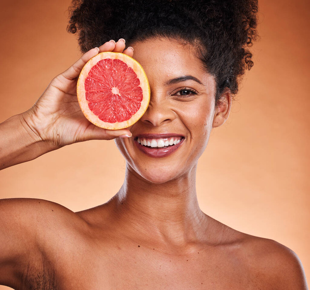 Grapefruit, black woman and beauty, skincare and wellness, healthy body and vitamin c, natural cosmetics and afro on studio background. Portrait of happy african model, citrus fruits and detox diet. - Foto, Bild