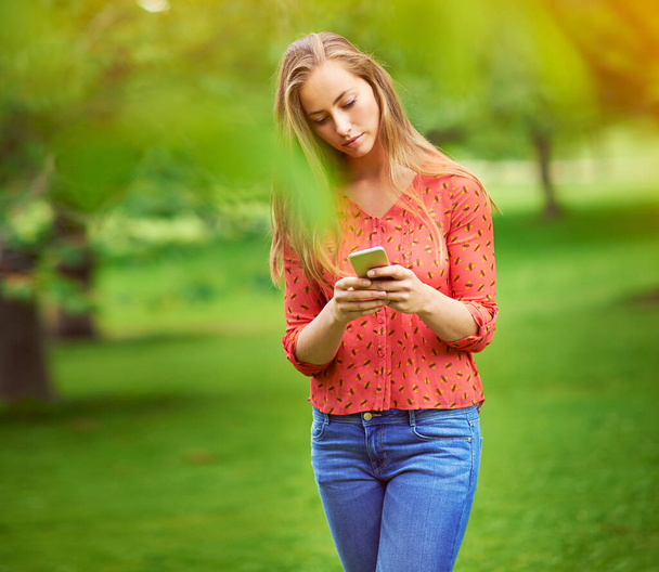 Я жду тебя в парке. молодая женщина пишет смс на мобильный на улице - Фото, изображение