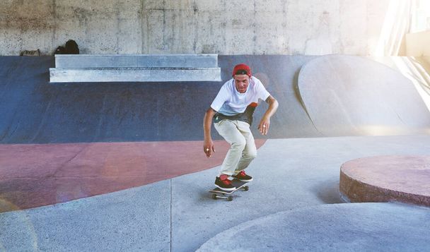 Do more of what makes you happy. a young man skating at a skatepark - Foto, imagen