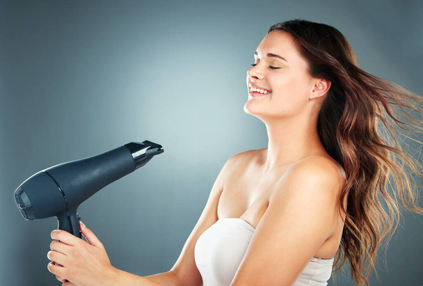 Hair, dryer and woman in studio for beauty, grooming and hair care on a gradient background with mockup. Hairstyle, model and girl relax while styling, blowing and enjoy hygiene, fresh and treatment. - Photo, image