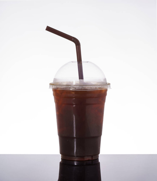 Café Ice americano en verre à emporter, sur fond blanc et sol en verre noir. - Photo, image