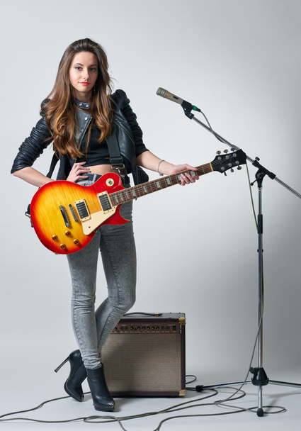 Молодая женщина с гитарой в руке
 - Фото, изображение