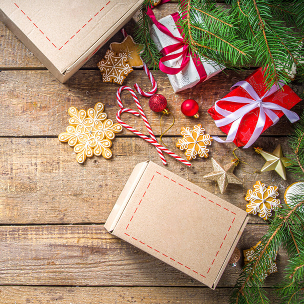 Χριστουγεννιάτικο πακέτο δώρου. Ανταλλαγή δώρων Χριστουγεννιάτικη Πρωτοχρονιά έννοια για covid-19 πανδημία. Μυστικό παιχνίδι μετά τον Άγιο Βασίλη. Συσκευασία δώρα, μπισκότα σε δέμα. Ξύλινο φόντο, με κλαδιά χριστουγεννιάτικου δέντρου και διακόσμηση - Φωτογραφία, εικόνα