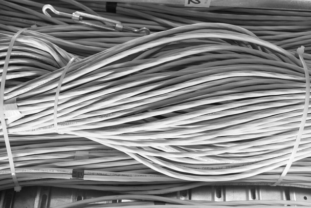 подробности большого количества кабелей Ethernet, связанных между собой соединительными стойками внутри серверной - Фото, изображение
