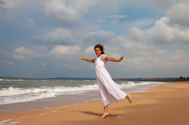woman in a white dress on the ocean coast - Фото, зображення