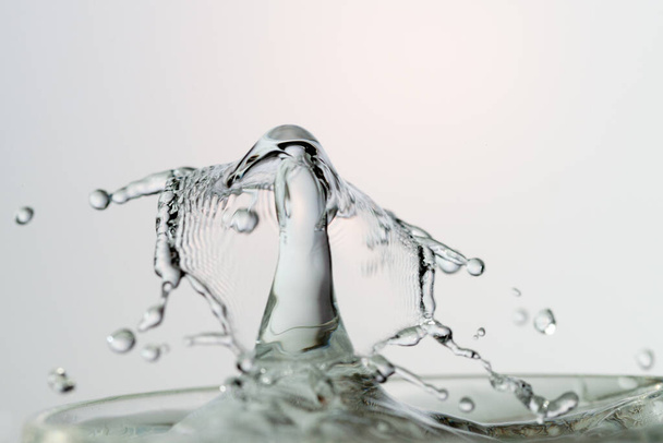 Gota de agua con ondulaciones en la superficie del agua - Foto, Imagen