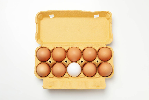 Egg box with eggs on white background, top view - Foto, afbeelding