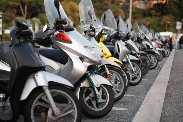 muitos scooters e motocicletas estão estacionados em uma longa fila - Foto, Imagem