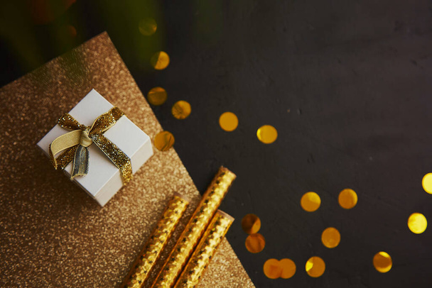 Christmas party black and golden background with gift, decorations and bright glitter. Copy space. - Φωτογραφία, εικόνα
