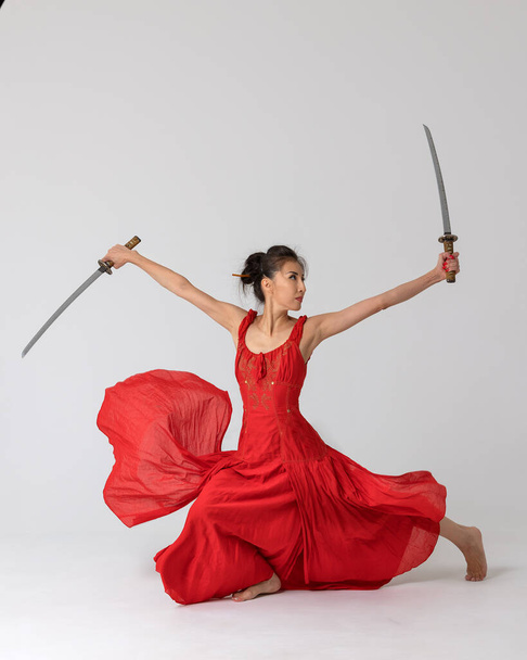 Aikido master woman in red dress with sword, katana on white background. Healthy lifestyle and sports concept. - Фото, зображення