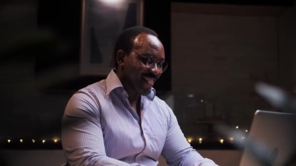 Αφρικανός κάνει βιντεοκλήση χρησιμοποιώντας φορητό υπολογιστή που κάθεται στο σπίτι.Επιχειρηματίας κάνει online επικοινωνία κοιτάζοντας υπολογιστή.Νέοι χαμογελαστοί άνδρες κάνουν συνάντηση με τους φίλους. Υψηλής ποιότητας 4k πλάνα - Πλάνα, βίντεο