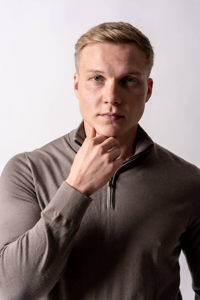portrait of a blonde caucasian man with brown sweater on a white background - 写真・画像