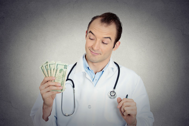 Grumpy greedy miserly health care professional holding money - Фото, зображення