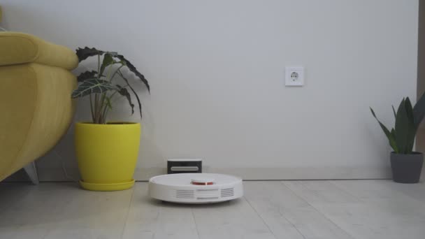 Moderne slimme elektronische huishoudtechnologie. Robot stofzuiger reinigt rond de tafel, slimme sensoren. Hoge kwaliteit 4k beeldmateriaal - Video