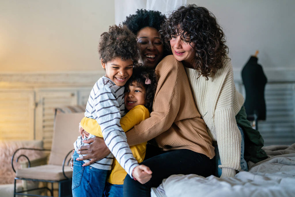 Gelukkig multi-etnische familie concept. glimlachen gay vrouwen paar spenderen tijd samen met kinderen thuis. - Foto, afbeelding
