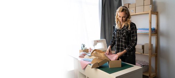 Startup small business entrepreneur SME, woman packing box. young seamstress small business owner in home office, online sell delivery, SME e-commerce concept. Banner - Foto, imagen