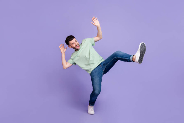 Full length photo of crazy astonished man wear trendy clothes jeans look up empty space afraid scared isolated on purple color background. - 写真・画像