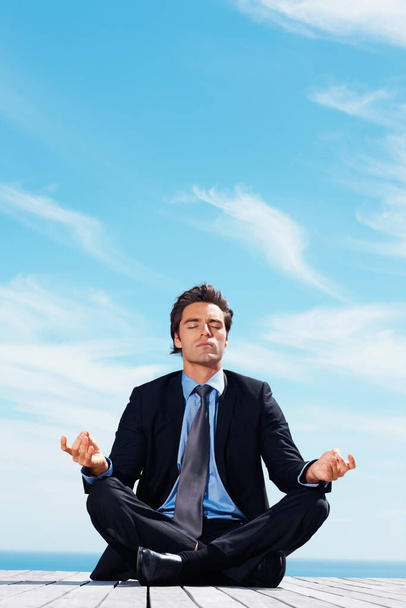 Hombre de negocios relajado meditando con copyspace en un muelle. Relajado joven hombre de negocios meditando con copyspace en un muelle - Foto, Imagen