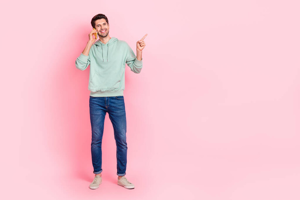 Full length photo of satisfied man trendy clothes arm direct empty space positive feedback device shop isolated on pink color background. - Zdjęcie, obraz