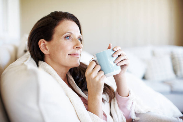 Pihenni és elmélkedni. Szoros kép egy vonzó nő élvezi egy csésze kávét, és keres szemlélődő - Fotó, kép