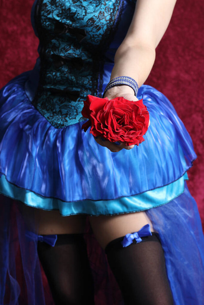 Close up of Red Rose in Hand of Woman Wearing Blue Corset Dress - Valokuva, kuva