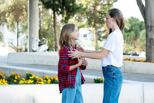 Eine Frau umarmt eine Tochter im Teenageralter und versucht, sie zu verstehen, von ihren Teenagerproblemen zu hören. Mama ist die beste Psychologin für ihre Kinder. Mutter und teen tochter kommunizieren. - Foto, Bild