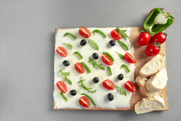 A board of butter or cream cheese on a wooden board. Appetizer. Top view. Butter board food trend, cracker with butter. - Photo, Image