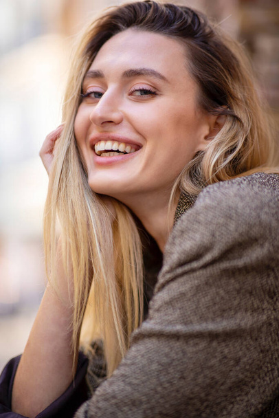 Κοντινό πλάνο πορτρέτο της όμορφης χαμογελαστής καυκάσιας γυναίκας με μακριά μαλλιά - Φωτογραφία, εικόνα