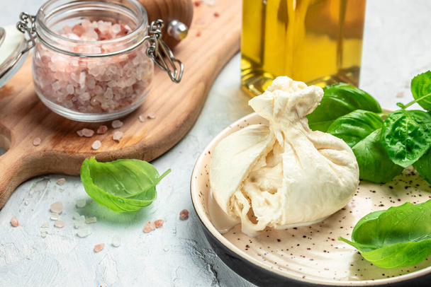 fresh soft white burrata cheese ball made from mozzarella and cream from Apulia, Italian Mediterranean cuisine, Food recipe background. Close up, - Фото, зображення