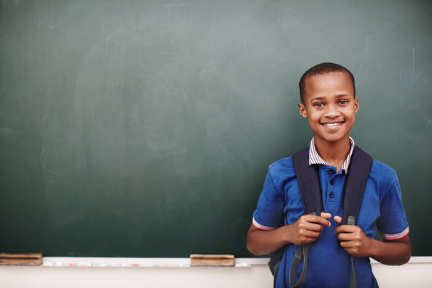 若い心は知識のための空白のスレートです。アフリカ系アメリカ人の少年が黒板の前に立っていて - 写真・画像