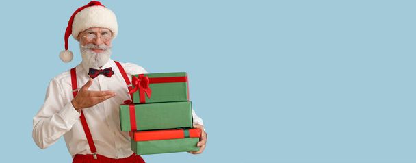Père Noël avec des cadeaux sur fond bleu clair avec espace pour le texte - Photo, image