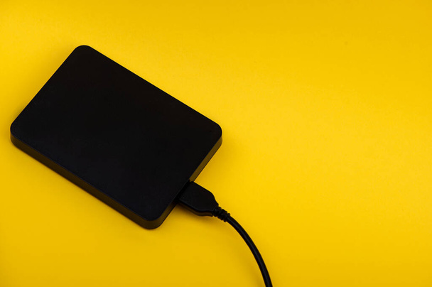 Disques durs portables externes noirs isolés sur fond jaune - Photo, image