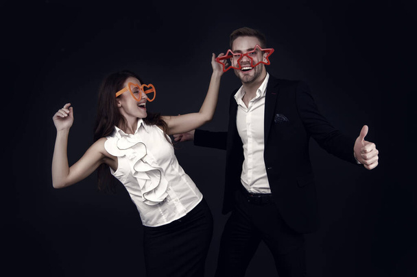We love fun. Happy couple have fun dark background. Sexy girl and handsome man wear giant fun glasses. Valentines day fun. Holiday celebration. Party and entertainment. Dance and enjoy. - Valokuva, kuva