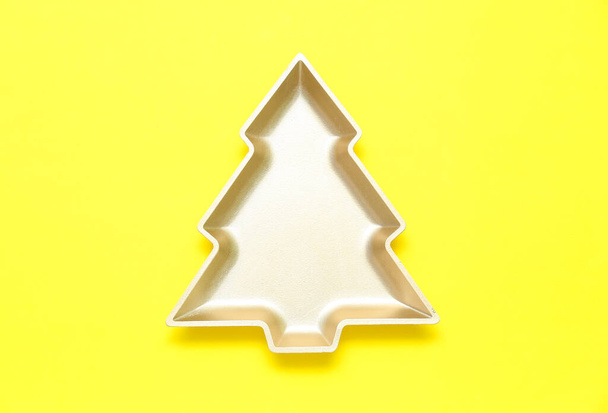 Beautiful plate in shape of Christmas tree on yellow background - Φωτογραφία, εικόνα