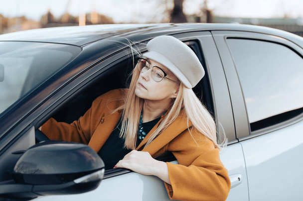 Жінка середнього віку керує машиною. Жінка з капелюхом і окулярами, концепція транспорту
 - Фото, зображення