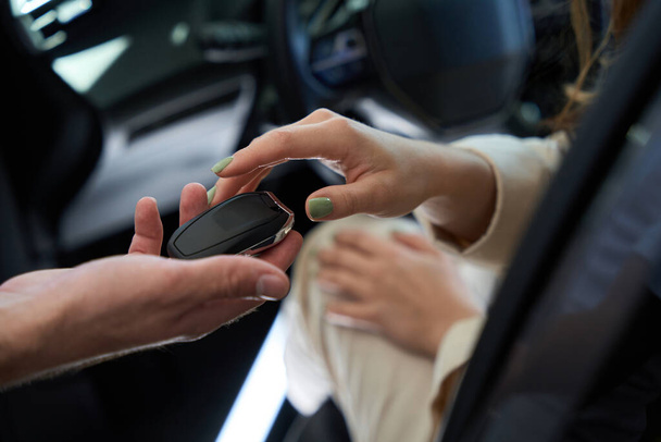 Cropped photo of buyer getting car remote control unit from sales consultant - 写真・画像