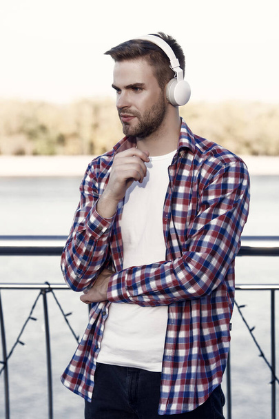 young man student in casual shirt and headset listen ebook and music while walking outdoor, inspiration. - Fotografie, Obrázek