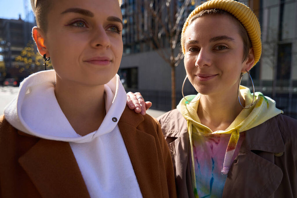 Happy girlfriends, lgbt couple, in modern comfortable clothes spend day off together, walk along the streets of a big city - Fotografie, Obrázek