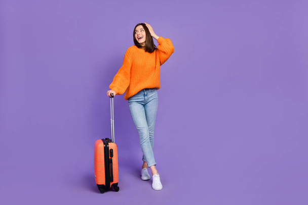 Full length photo of nice young lady touch head impressed traveler dressed stylish orange knitted look isolated on purple color background. - Φωτογραφία, εικόνα