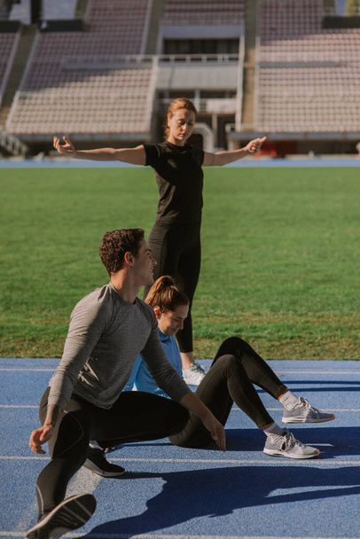 Beautiful sporty friends are exercising together while having a fun conversation - Photo, Image