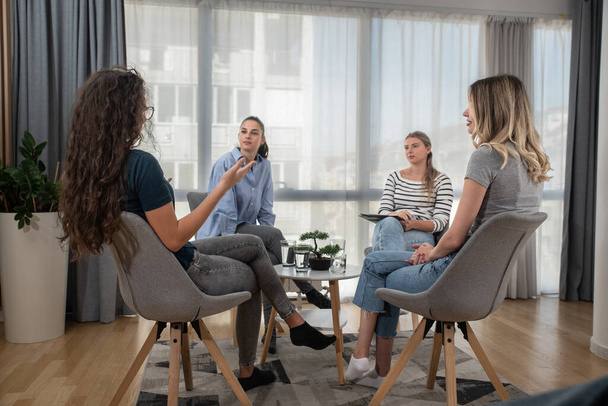 Group of young women small company and new business owners, fashion designers and bloggers team building and staff meeting. Female friends talking and discussing about new ideas and solutions.  - Zdjęcie, obraz