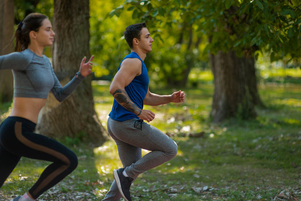 A handsome male is running in the park with his lovely girlfriend - Foto, immagini