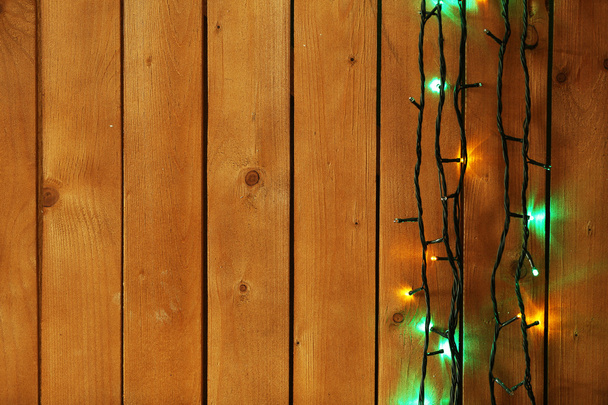 木製の背景にクリスマスライトガーランド - 写真・画像