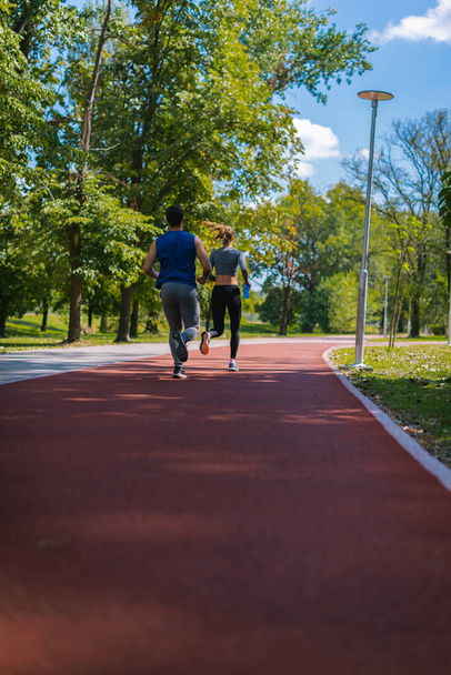 Δύο μοντέλα φυσικής κατάστασης ενηλίκων που τρέχουν στο πάρκο - Φωτογραφία, εικόνα